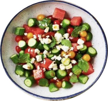 A colorful salad in a bowl features diced watermelon, cucumbers, cherry tomatoes, yellow tomatoes, crumbled feta cheese, and mint leaves. GREENHOUSE Goodness A colorful salad in a bowl features diced watermelon, cucumbers, cherry tomatoes, yellow tomatoes, crumbled feta cheese, and mint leaves. GREENHOUSE Goodness