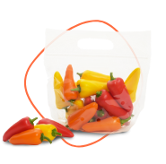 A clear plastic bag filled with assorted small bell peppers, including red, yellow, and orange ones. A few peppers are placed outside the bag on the surface. GREENHOUSE Goodness